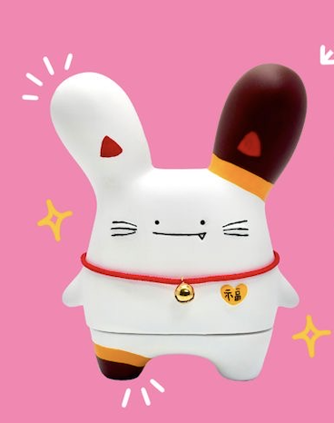 White lucky-cat Rabitt Planet sofubi figure with a bell on a pink background