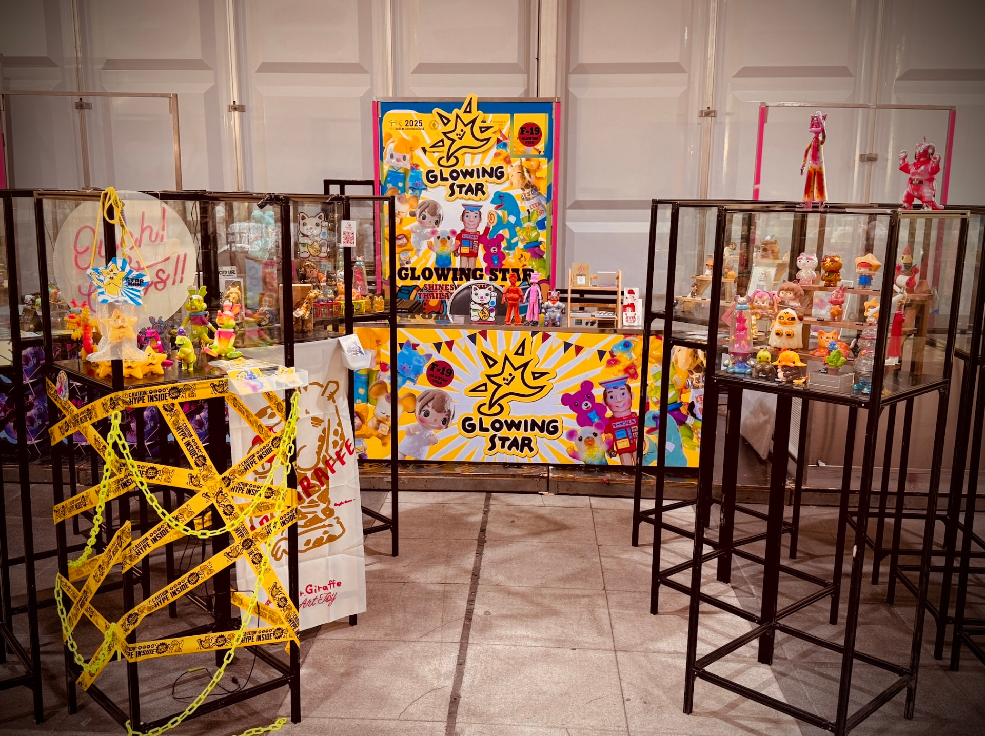 The Glowing Star booth at Thailand Toy Expo in Bangkok, with the branded backdrop, counter and flanking display towers