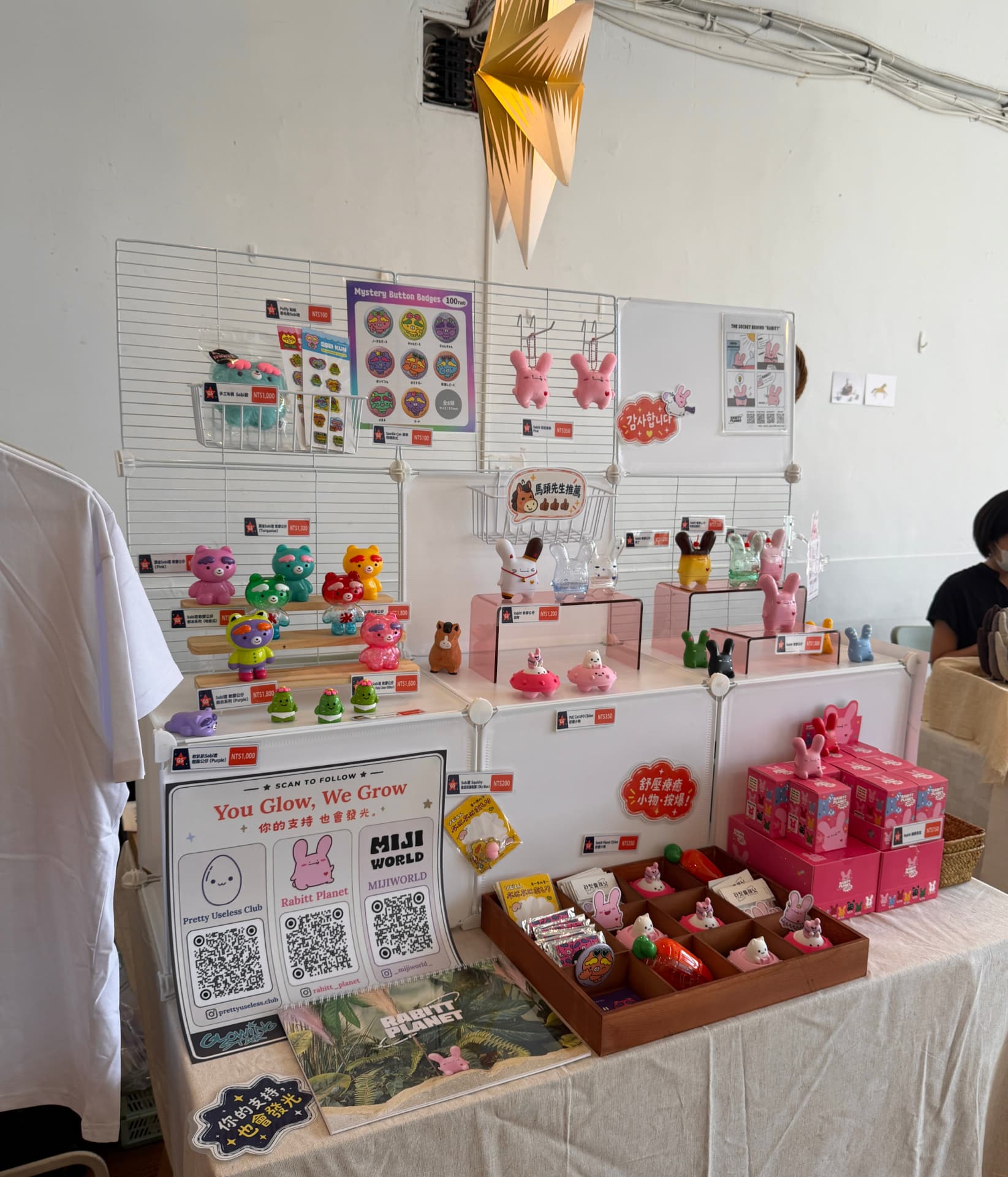 The Glowing Star stall at the GalaGala September Weekend Market in Taipei, with tiers of Rabitt Planet and MIJI WORLD figures, mystery badge packs and the You Glow, We Grow follow sign on the table