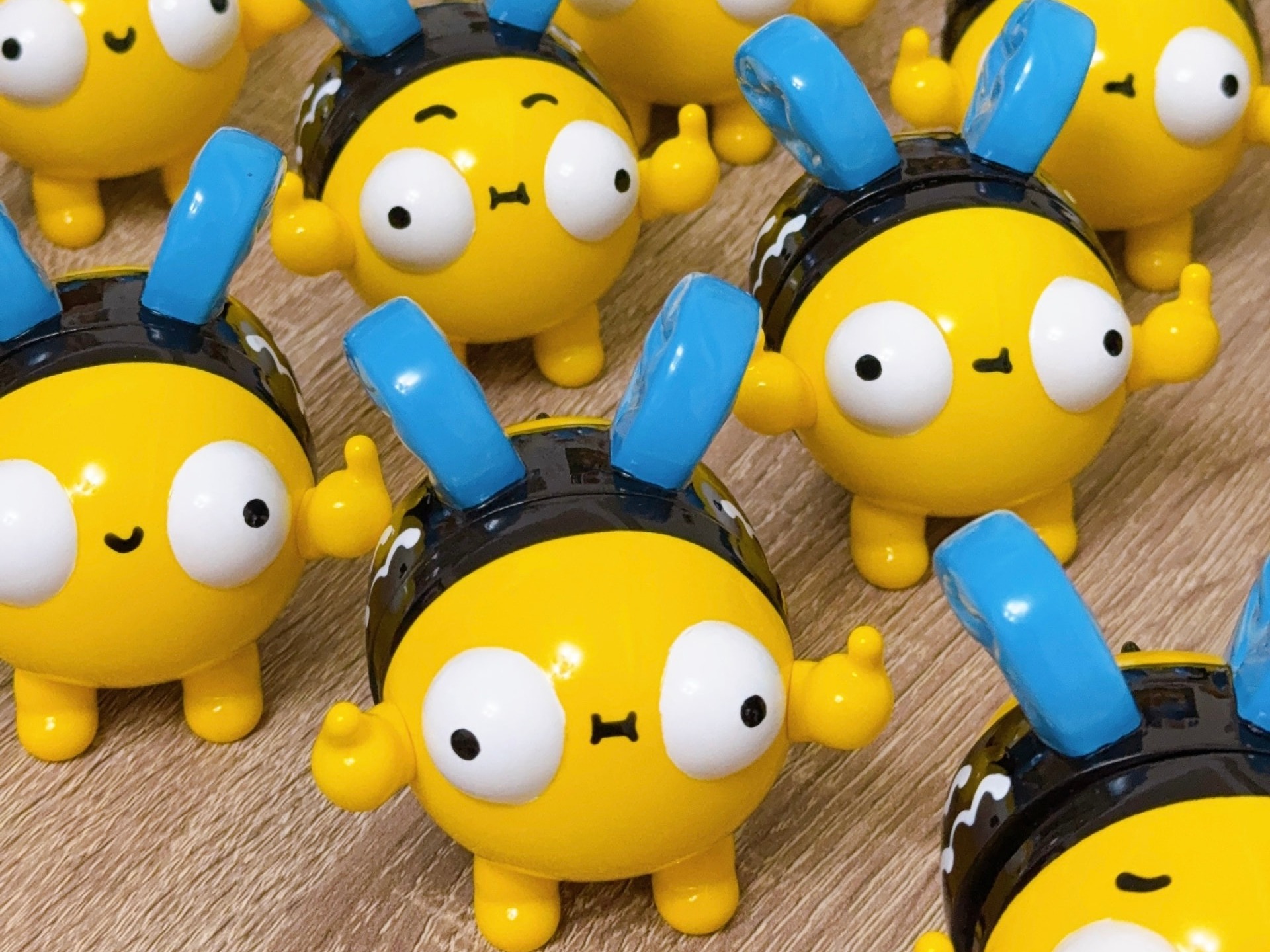 A crowd of Super Bee figures standing in rows on a wooden table